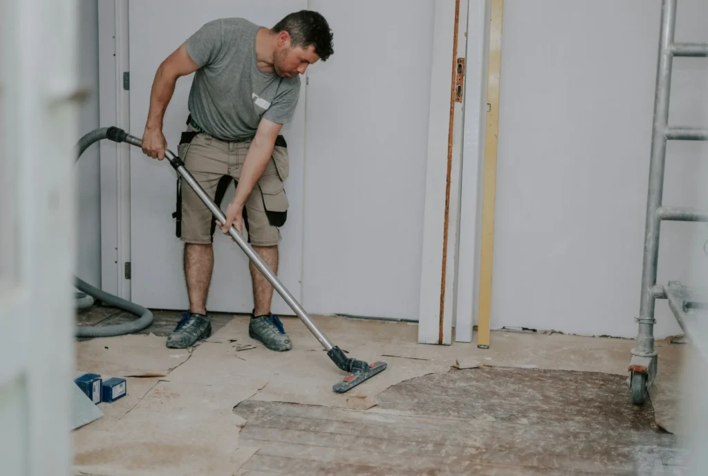 a-young-man-vacuums-the-floor-with-a-construction-2026-01-08-22-23-11-utc